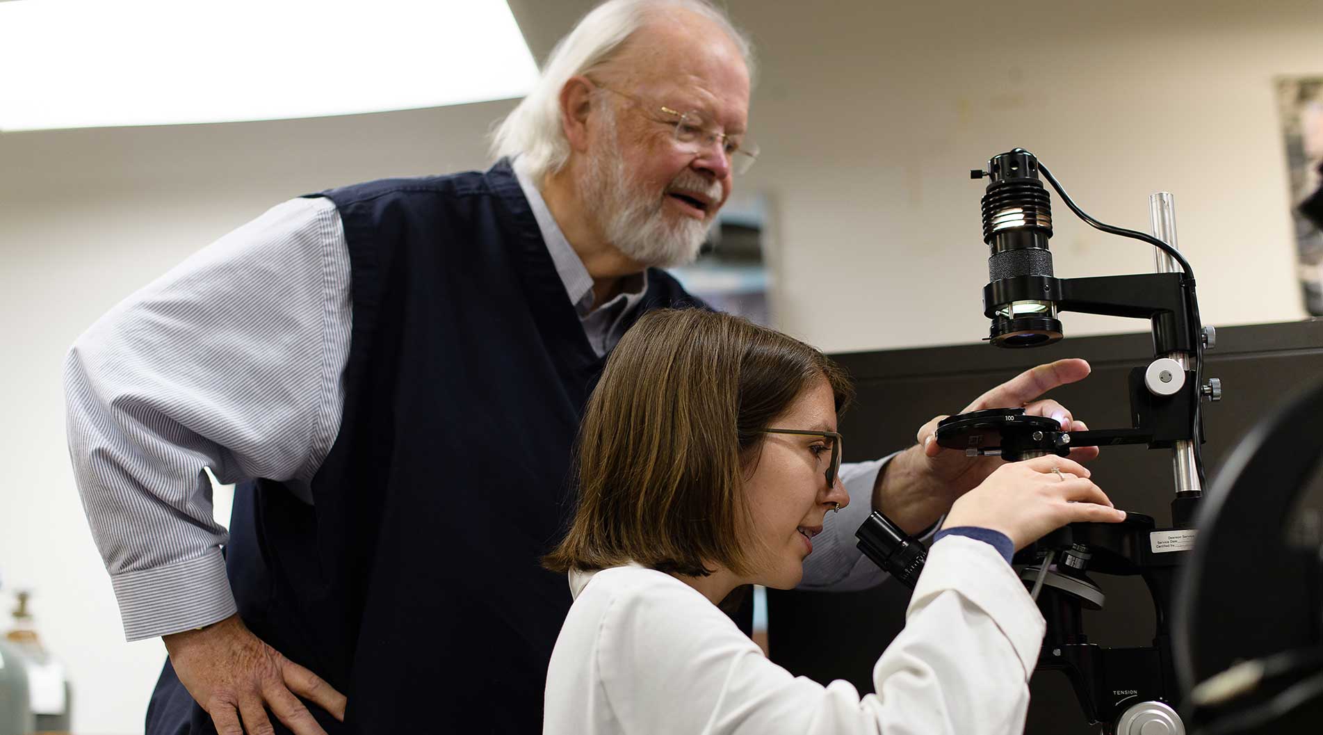 student and teacher looking through a microscope