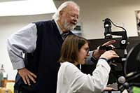 student and teacher looking through a microscope